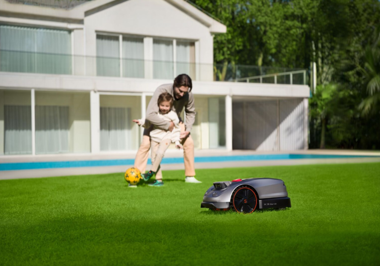 Sunseeker X3 Gen 2 safely mowing a lawn while children&nbsp;play nearby