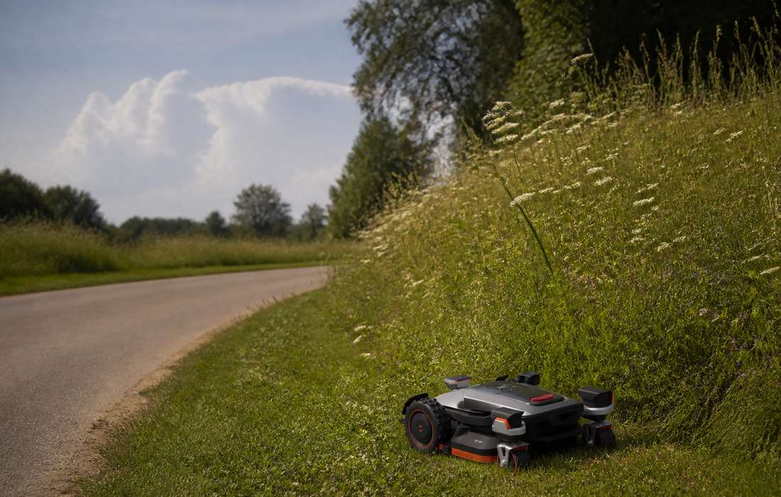 x9 seriesn robot mower sloping roadside with flowers