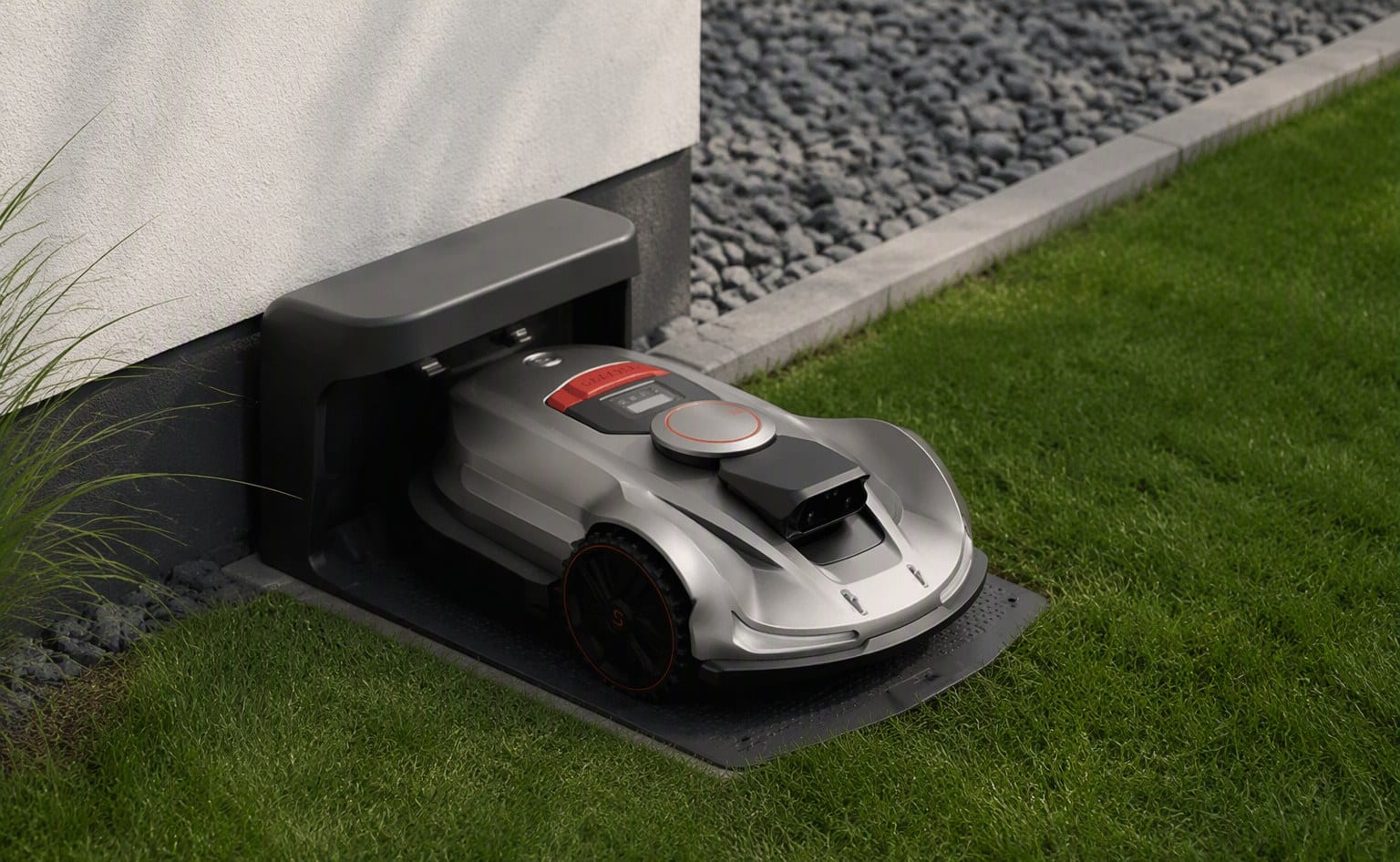 Sunseeker robot mower docked at its charging station beside a house wall