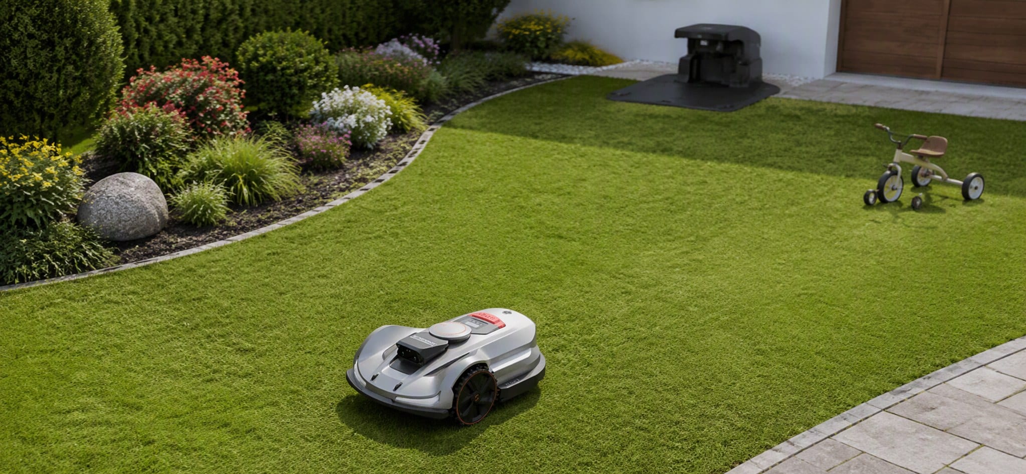 Residential lawn with a Sunseeker robot mower, a lawn boundary beside a planting bed, open mowing space, a garden obstacle and a charging dock